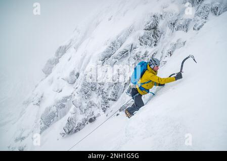 Eisklettern für Männer bei Schnee und Frost Stockfoto