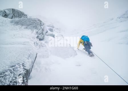 Eisklettern für Männer bei Schnee und Frost Stockfoto