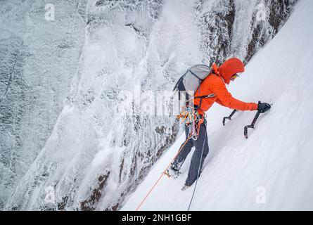 Eisklettern für Männer bei Schnee und Frost Stockfoto