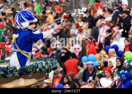 Köln, Deutschland. 20. Februar 2023. Ein Karnevalsarbeiter wirft Süßigkeiten ins Publikum. Kredit: Oliver Berg/dpa/Alamy Live News Stockfoto