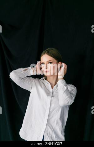 Porträt einer Frau in einem weißen Hemd im Studio Stockfoto