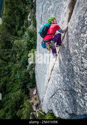 Ein Mann klettert steil auf einem Felsgesicht Stockfoto