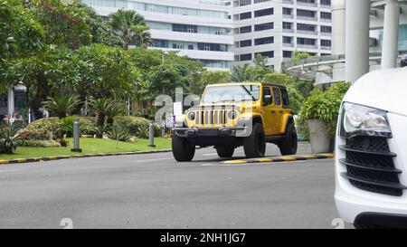 Surabaya, Ost-Java, Indonesien - Februar 2023 : Gelber Jeep Wrangler Rubicon eine der Ausgabevarianten des US-amerikanischen Automobilherstellers Stockfoto