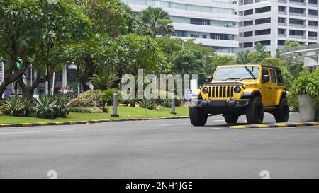 Surabaya, Ost-Java, Indonesien - Februar 2023 : Gelber Jeep Wrangler Rubicon eine der Ausgabevarianten des US-amerikanischen Automobilherstellers Stockfoto