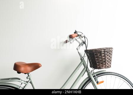 Altes grünes Fahrrad mit braunem Korb auf weißem Hintergrund Stockfoto