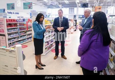 Innenministerin Suella Braverman (links) während eines Besuchs bei Boots im Gemini Retail Park in Warrington, Cheshire, als Teil der Ankündigung eines harten Vorgehens gegen häusliche Gewalt. Die gefährlichsten häuslichen Täter werden genauer beobachtet und mit einer Reihe neuer Vorschläge zur Bekämpfung der Kriminalität elektronisch gekennzeichnet. Foto: Montag, 20. Februar 2023. Stockfoto