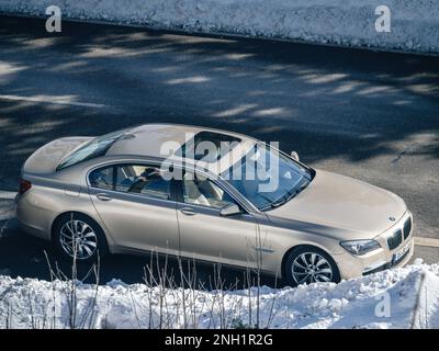 Deutschland – 10. Februar 2023: Luftaufnahme des luxuriösen BMW der Serie 7 in Champagner Metallic mit Innenausstattung aus hellem Leder an einem Wintertag in einer ländlichen Bergstraße Stockfoto