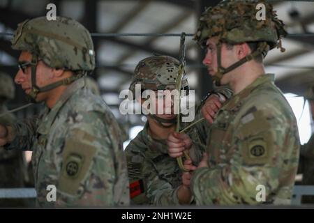 Ein Sprungmeister überprüft die statische Leitung eines Fallschirmjägers während eines anhaltenden Flugtrainings, bevor ein taktischer Massensprung von Fallschirmjägern aus dem 2. Brigade-Kampfteam, 82. Luftwaffe, in Fort Bragg, North Carolina, 7. Dezember, (2022) Ziel der Schulung ist es, die Befähigung im Flugbetrieb und bei missionswichtigen Aufgaben aufrechtzuerhalten und zu verbessern. Stockfoto