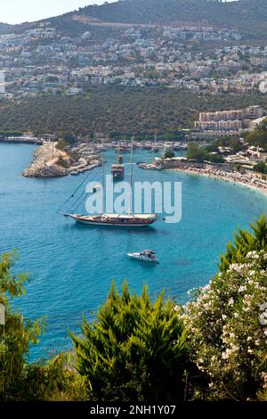 Boote ( Gulets ), die in der Bucht von Kalkan vor Anker liegen, mit dem Hafen von Kalkan im Hintergrund, Türkei. Juli 2022 Stockfoto