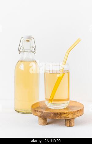 Hausgemachter Kombucha fermentierter Drink in Glas und Flasche auf weißem Hintergrund. Heathisches probiotisches Getränk mit Blasen. Alkoholfreie Getränke im Sommer. Seitenansicht, Kopierbereich Stockfoto