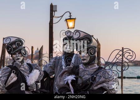 Karnevalsbesucher, die im Februar während des Karnevals 2023 in Venedig in prächtigen Kostümen und Masken gekleidet waren, am Markusplatz in Venedig, Italien Stockfoto