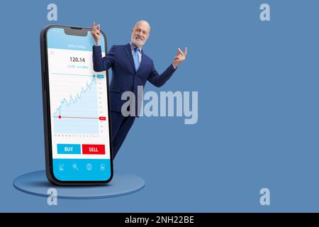 Erfolgreicher Geschäftsmann, der mit den Fingern schnippt und im Online-Handel Geld verdient: Finanzanwendung auf einem großen Smartphone, leerer Kopierbereich Stockfoto