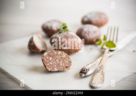 Schokoladen-Süßkuchen aus pürierten Keksen mit Zusatzstoffen auf Backpapier. Stockfoto