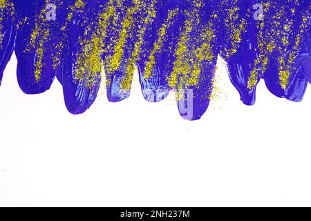 Auf weißem Hintergrund, blaue schillernde Flecken von fließender Acrylfarbe mit Goldglitzern. Stockfoto