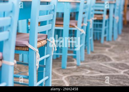 Eine Reihe von Stühlen, die in einer traditionellen griechischen Taverne im Dorf Chora, Folegandros, blau gestrichen wurden Stockfoto