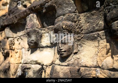 Alte und verwitterte Gesichter in Sandstein auf der Terrasse des Lweper King im Angkor-Komplex in Kambodscha. Stockfoto