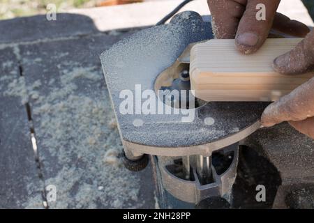 Holzbearbeitung auf einer Fräsmaschine, Handwerksholzbearbeitung mit Elektrowerkzeugen, Stockfoto