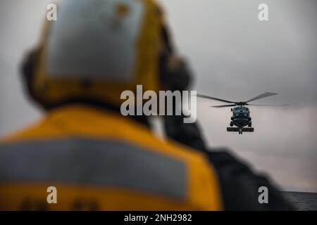 221207-N-GF955-1078 OSTSEE (7. DEZEMBER 2022) USA Navy Boatswain's Mate 1. Class Nicholas Labarre führt einen Helikopter der Royal Danish Air Force MH-60R Sea Hawk zur Landung auf dem Cockpit des Guided-Missile Destroyer USS Paul Ignatius (DDG 117) der Arleigh-Burke-Klasse während der Deckslandung, 7. Dezember 2022. Paul Ignatius, der nach Rota, Spanien, geschickt wird, befindet sich in einem geplanten Einsatz in den USA Marinestreitkräfte Europa Einsatzgebiet, angestellt von den USA Sechste Flotte, um die Interessen der USA, Verbündeten und Partner zu verteidigen. Stockfoto