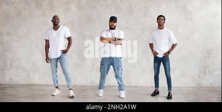 Collage von drei verschiedenen Männern, Ganzkörper an strukturierten grauen Wänden, gekleidet in Jeans und weißen T-Shirts. Ernsthafte Typen, Modemodelle Stockfoto