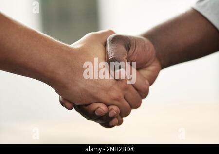 Es war mir ein Vergnügen, mit Ihnen Geschäfte zu machen. Zwei unbekannte Geschäftsmänner, die im Büro standen und sich die Hand gaben. Stockfoto