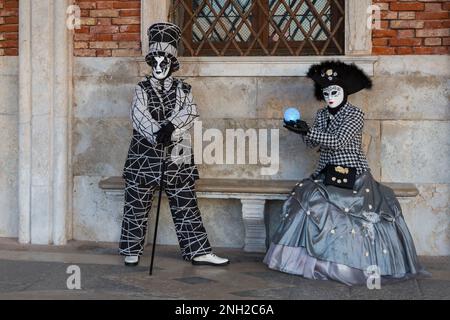 Karnevalsbesucher, die im Februar während des Karnevals 2023 in Venedig in prächtigen Kostümen und Masken gekleidet waren, am Markusplatz in Venedig, Italien Stockfoto