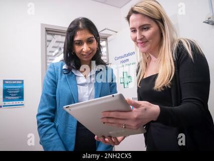 Innenministerin Suella Braverman (links) zeigt Bright Sky, eine App für Unterstützung und Informationen über häusliche Gewalt, von Sarah D'Angelis von der Wohltätigkeitsorganisation Hestia, Während eines Besuchs in einem sicheren Raum, der Teil des Ask for ANI-Programms ist, das es Personen, die von Missbrauch bedroht oder betroffen sind, ermöglicht, diskret zu signalisieren, dass sie Hilfe und Zugang zu Unterstützung benötigen, im Boots im Gemini Retail Park in Warrington, Cheshire, Als Teil der Ankündigung eines harten Vorgehens gegen häusliche Gewalt. Die gefährlichsten häuslichen Missbrauchsfälle werden genauer beobachtet und mit einer Reihe neuer Vorschläge elektronisch gekennzeichnet Stockfoto