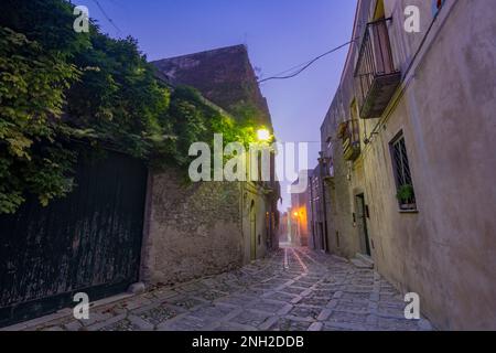 Eine charakteristische Gasse im mittelalterlichen Dorf Erice bei Einbruch der Dunkelheit, Sizilien Stockfoto