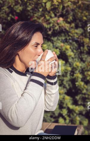 Eine Pause machen Latina-Frau, die Kaffee im Garten trinkt Stockfoto