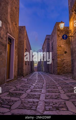 Eine charakteristische Gasse im mittelalterlichen Dorf Erice bei Einbruch der Dunkelheit, Sizilien Stockfoto