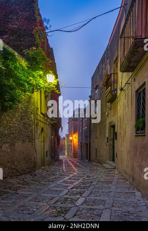 Eine charakteristische Gasse im mittelalterlichen Dorf Erice bei Einbruch der Dunkelheit, Sizilien Stockfoto