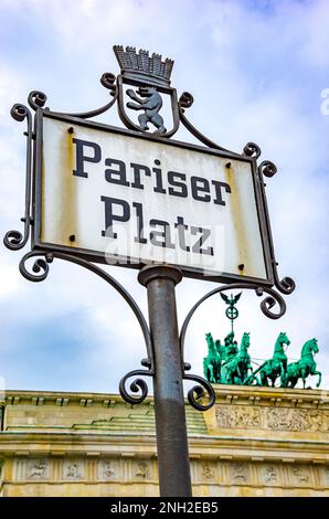 Schild mit der Aufschrift Pariser Platz am Ende der Straße unter den Linden mit dem Brandenburger Tor im Hintergrund, Berlin, Deutschland. Stockfoto