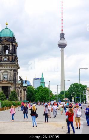 Alltägliches geschäftiges Treiben voller Touristen auf dem Berliner Schlossplatz mit Blick auf den Dom und den Fernsehturm in Berlin. Stockfoto