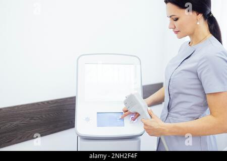 Porträt einer jungen Ärztin, die sich für die SMAS Ultraschall-Gesichtsliftmassage mit professioneller Ausrüstung im Beauty Center vorbereitet Stockfoto
