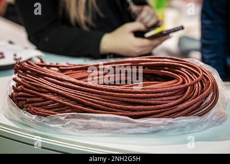 Ein Haufen gerollter, lang geräucherter Würstchen auf einem Schaukasten von Bauernladen, Markt Stockfoto