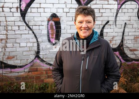 Porträt einer Frau, die vor einer Graffiti-Wand steht. Manchester. Vereinigtes Königreich. Stockfoto