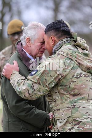 König Karl III. Erhält die Hongi - die traditionelle Begrüßung der Maori - von einem Neuseeländer, der Teil des ukrainischen Kontingents ist, während eines Besuchs an einem Ausbildungsort für ukrainische Militärangehörige in Wiltshire, Dort absolvieren Rekruten eine fünfwöchige Grundausbildung britischer und internationaler Partnerstreitkräfte, bevor sie in die Ukraine zurückkehren. Foto: Montag, 20. Februar 2023. Stockfoto