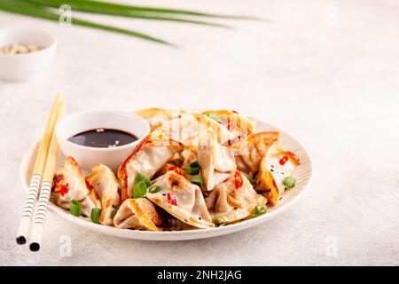 Gebratene Knödel mit grünen Zwiebeln, Sesam und Chilischoten. Stockfoto