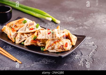 Gebratene Knödel mit grünen Zwiebeln, Sesam und Chilischoten. Stockfoto