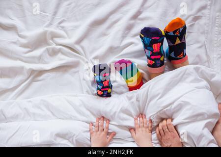 Bunte Socken an den Füßen als Symbol des Weltuntergangssyndroms. Stockfoto