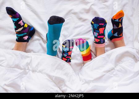 Bunte Socken an den Füßen als Symbol des Weltuntergangssyndroms. Stockfoto