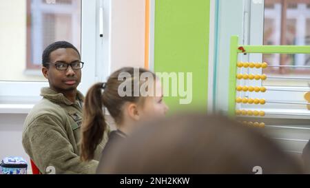 Greywolf Trooper, SPC. Tyrell Kinley, Hauptquartier und Hauptquartier, 215. Brigadestützbataillon, 3. Kampfteam der Panzerbrigade, 1. Kavallerieabteilung, interagiert mit polnischen Schülern der Grundschule. Major H. Sucharskiego, 9. Dezember 2022. Ereignisse wie diese stärken weiterhin die Bande zwischen der polnischen Gemeinschaft und der US-Armee. Stockfoto