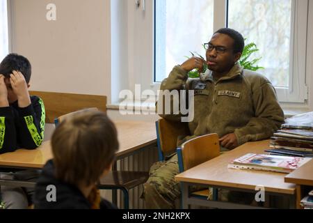 Greywolf Trooper, SPC. Tyrell Kinley, Hauptquartier und Hauptquartier, 215. Brigadestützbataillon, 3. Kampfteam der Panzerbrigade, 1. Kavallerieabteilung, interagiert mit polnischen Schülern der Grundschule. Major H. Sucharskiego, 9. Dezember 2022. Ereignisse wie diese stärken weiterhin die Bande zwischen der polnischen Gemeinschaft und der US-Armee. Stockfoto