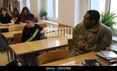 Greywolf Trooper, SPC. Tyrell Kinley, Hauptquartier und Hauptquartier, 215. Brigadestützbataillon, 3. Kampfteam der Panzerbrigade, 1. Kavallerieabteilung, interagiert mit polnischen Schülern der Grundschule. Major H. Sucharskiego, 9. Dezember 2022. Ereignisse wie diese stärken weiterhin die Bande zwischen der polnischen Gemeinschaft und der US-Armee. Stockfoto