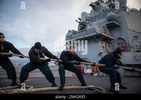 221208-N-GF955-1036 KIEL, Deutschland (8. Dezember 2022) USA Marinesoldaten, die dem Arleigh-Burke-Klasse-Guided-Missile-Zerstörer USS Paul Ignatius (DDG 117) zugeteilt wurden, legen sich um eine Linie, wenn das Schiff in Kiel ankommt, um einen planmäßigen Hafenbesuch am 8. Dezember 2022. Paul Ignatius, der nach Rota, Spanien, geschickt wird, befindet sich in einem geplanten Einsatz in den USA Marinestreitkräfte Europa Einsatzgebiet, angestellt von den USA Sechste Flotte, um die Interessen der USA, Verbündeten und Partner zu verteidigen. Stockfoto