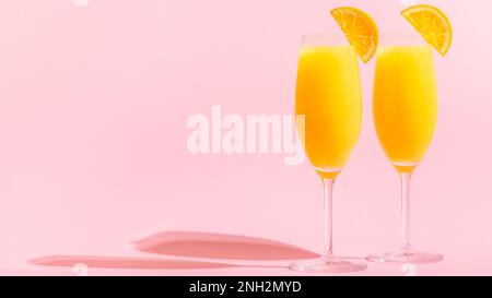 Erfrischende orangene Mimosa-Cocktails mit Champagner auf hellem Hintergrund. Stockfoto