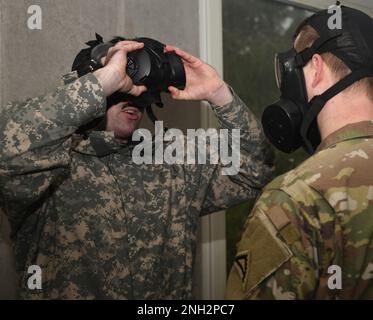 USA Der Armeebedienstete Nicholas Paris, ein Ausbilder im Combined Arms Training Center des 7. Army Training Command, beobachtet, wie Soldaten während des CBRN-Verteidigungskurses (Chemical, Biological, Radiological, and Nuclear) in Grafenwoehr, Deutschland, am 8. Dezember 2022 Masken-Vertrauensübungen in der Gaskammer durchführen. Der CBRN-Verteidigungskurs schult Soldaten in der Überwachung und Umsetzung missionsorientierter Schutzhaltung, CBRN-Berichte auf Einheitsebene, radiologische Überwachung, Dekontaminationsoperationen, Durchführung von CBRN-Verteidigungsübungen und radiologische Operationen der Einheit. Stockfoto