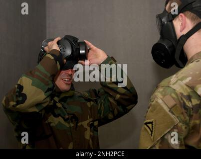 USA Der Armeebedienstete Nicholas Paris, ein Ausbilder im Combined Arms Training Center des 7. Army Training Command, beobachtet, wie Soldaten während des CBRN-Verteidigungskurses (Chemical, Biological, Radiological, and Nuclear) in Grafenwoehr, Deutschland, am 8. Dezember 2022 Masken-Vertrauensübungen in der Gaskammer durchführen. Der CBRN-Verteidigungskurs schult Soldaten in der Überwachung und Umsetzung missionsorientierter Schutzhaltung, CBRN-Berichte auf Einheitsebene, radiologische Überwachung, Dekontaminationsoperationen, Durchführung von CBRN-Verteidigungsübungen und radiologische Operationen der Einheit. Stockfoto