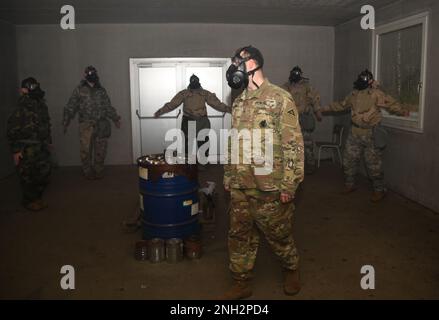 USA Der Armeebedienstete Nicholas Paris, ein Ausbilder im Combined Arms Training Center des 7. Army Training Command, beobachtet, wie Soldaten während des CBRN-Verteidigungskurses (Chemical, Biological, Radiological, and Nuclear) in Grafenwoehr, Deutschland, am 8. Dezember 2022 Masken-Vertrauensübungen in der Gaskammer durchführen. Der CBRN-Verteidigungskurs schult Soldaten in der Überwachung und Umsetzung missionsorientierter Schutzhaltung, CBRN-Berichte auf Einheitsebene, radiologische Überwachung, Dekontaminationsoperationen, Durchführung von CBRN-Verteidigungsübungen und radiologische Operationen der Einheit. Stockfoto