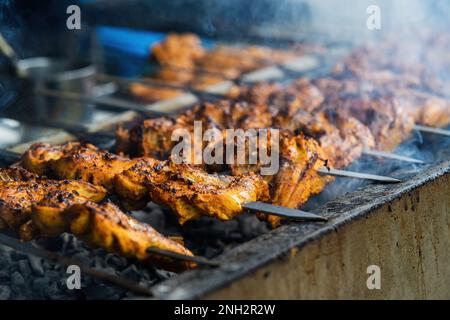 Hähnchenspieß-Kebab-Grill. Traditionelles indisches und paksitanisches Gericht mit Holzkohle und Flammen. Stockfoto