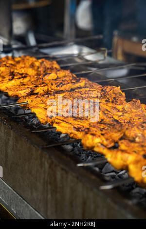 Kochen Hähnchenschief Kebab Grill. Traditionelles indisches und paksitanisches Gericht, gekocht auf Holzkohle und Flamme. Stockfoto